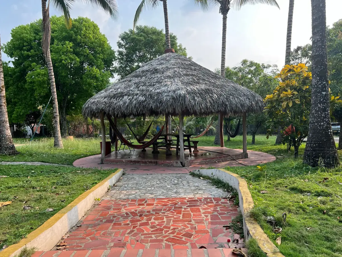 Kiosko con techo de palma y hamacas en La MariaCa